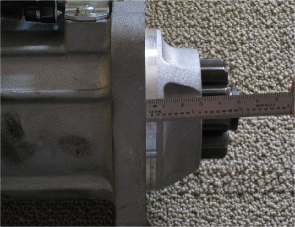 Measuring the space between the bellhousing and starter motor shown from a different angle.